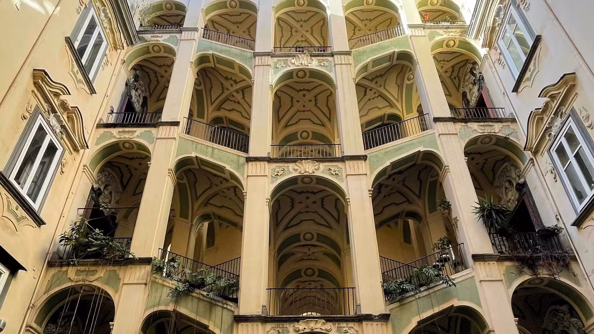 Elegant courtyard arches with intricate architectural details in Naples' historic Sanità district.