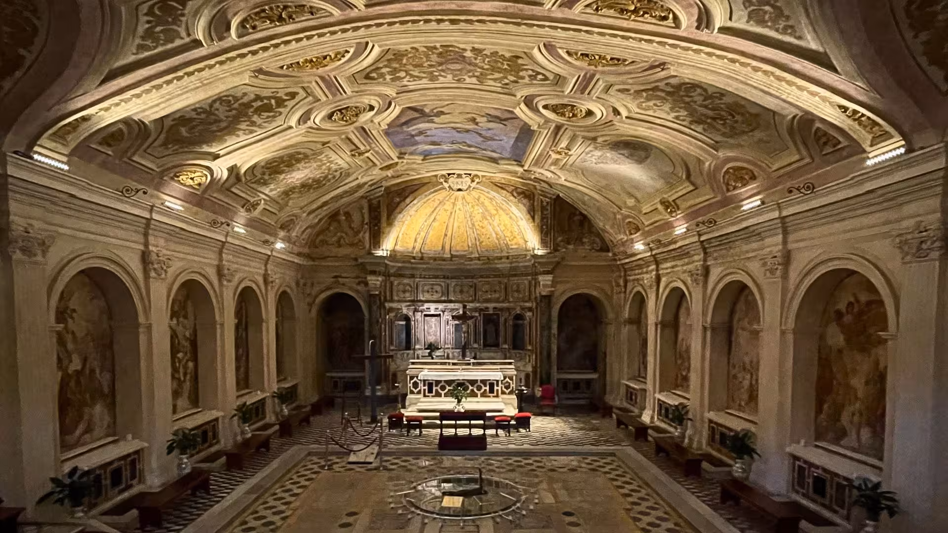 Explore the ornate interior of a historic chapel in Naples' Sanità district, featuring intricate frescoes and architecture.