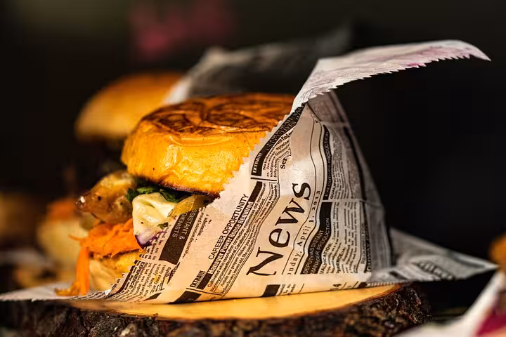 Delicious street food burger wrapped in newspaper at Naples market, perfect for a culinary walking tour adventure.