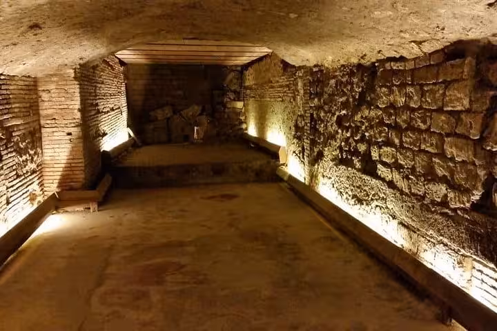 Illuminated underground chamber with ancient brick walls in Naples, perfect for exploring historical ruins on a guided tour.