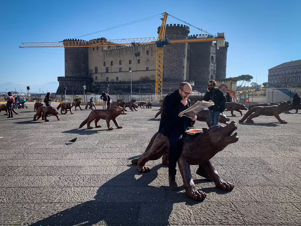 Modern art wolf sculptures in front of medieval Castel Nuovo on a sunny Naples walking tour near the underground city