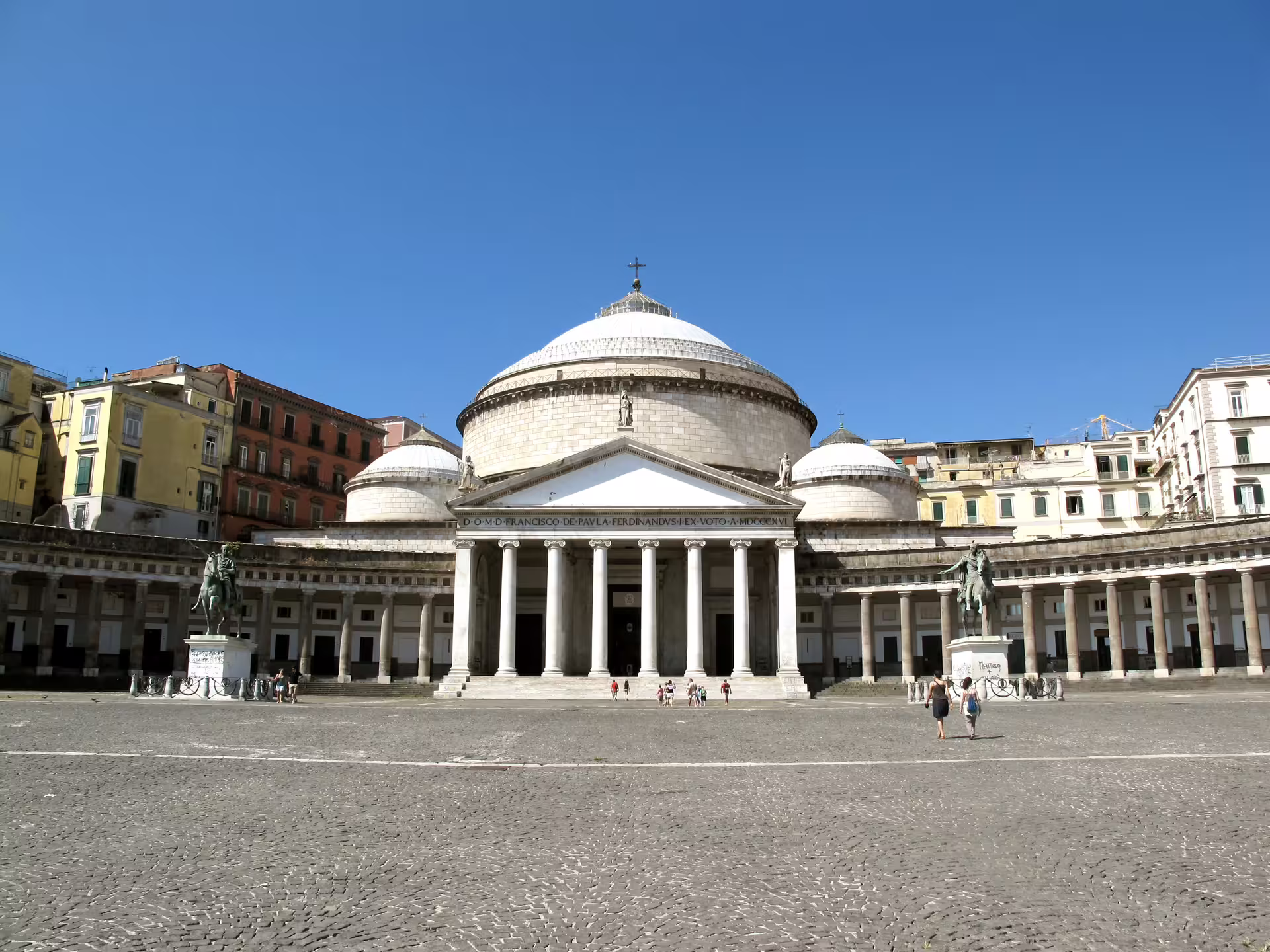 Tourists crossing Piazza del Plebiscito toward the Basilica of San Francesco di Paola on a central stop of the Naples walking tour