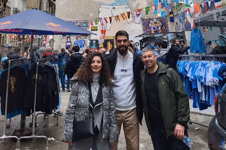 Local guide with guests browsing Napoli fan shop street market, scarves and jerseys in central Naples
