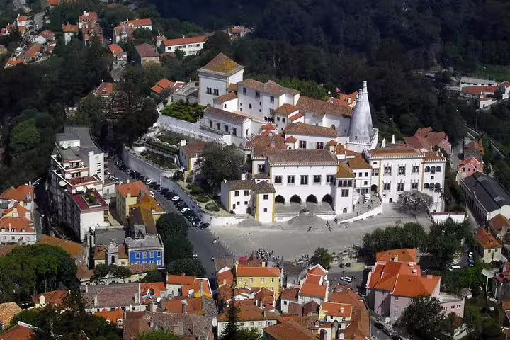 Aerial view of the historic National Palace of Sintra surrounded by vibrant rooftops, ideal for a full-day private tour from Lisbon.
