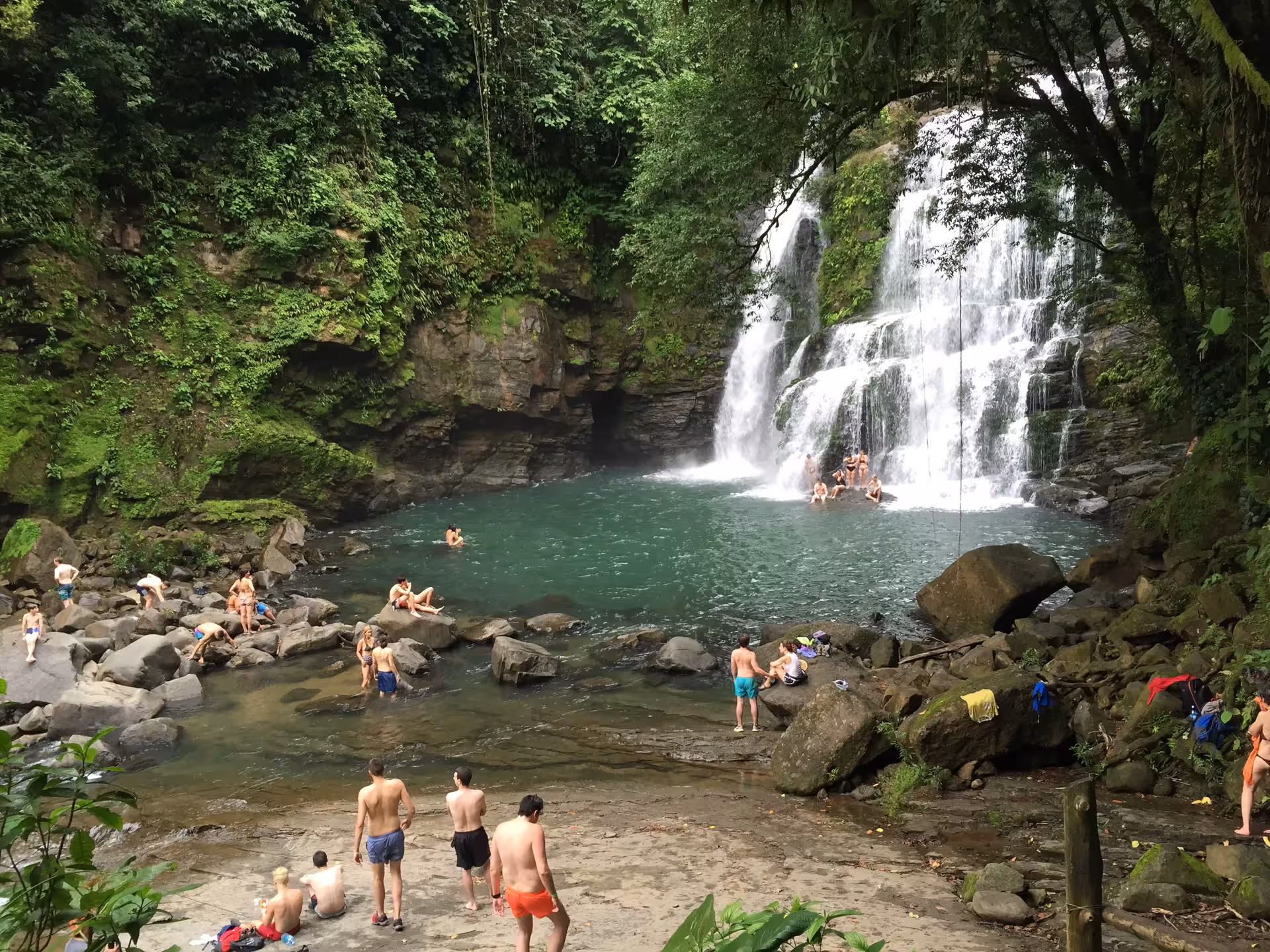 Visitors enjoy swimming and relaxing at the scenic Nauyaca Waterfalls surrounded by lush jungle near Manuel Antonio.