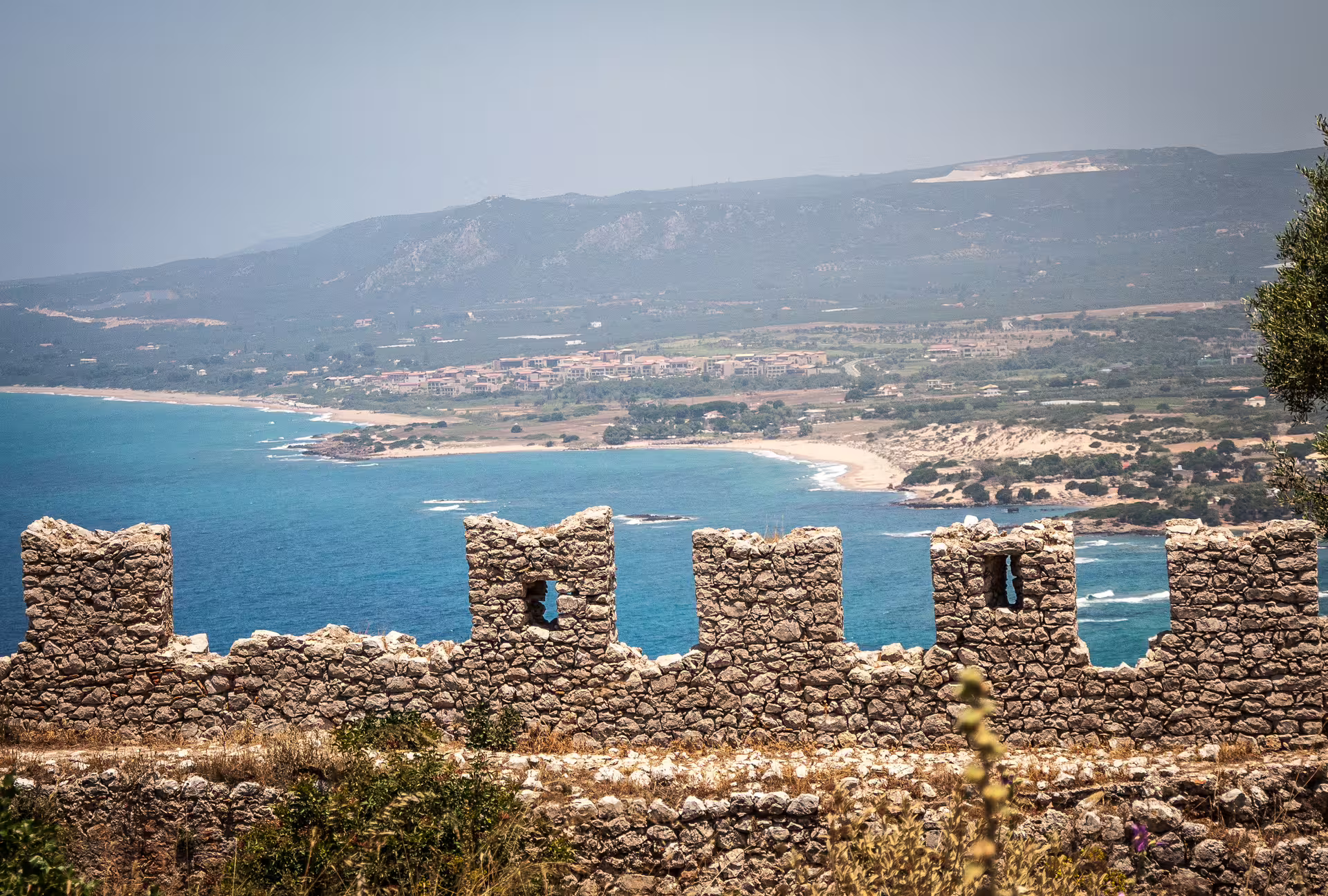 Navarino Bay coastal hike view from stone fortress ruins over turquoise sea and sandy beaches, Peloponnese