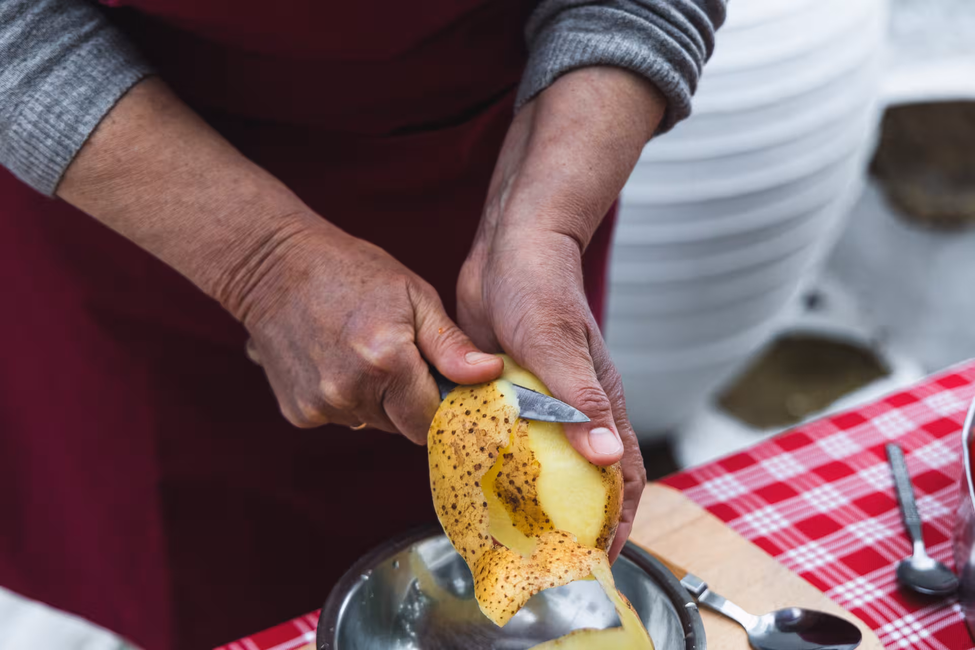 Peeling a potato for Greek island recipes at a Naxos traditional cooking and cheesemaking class