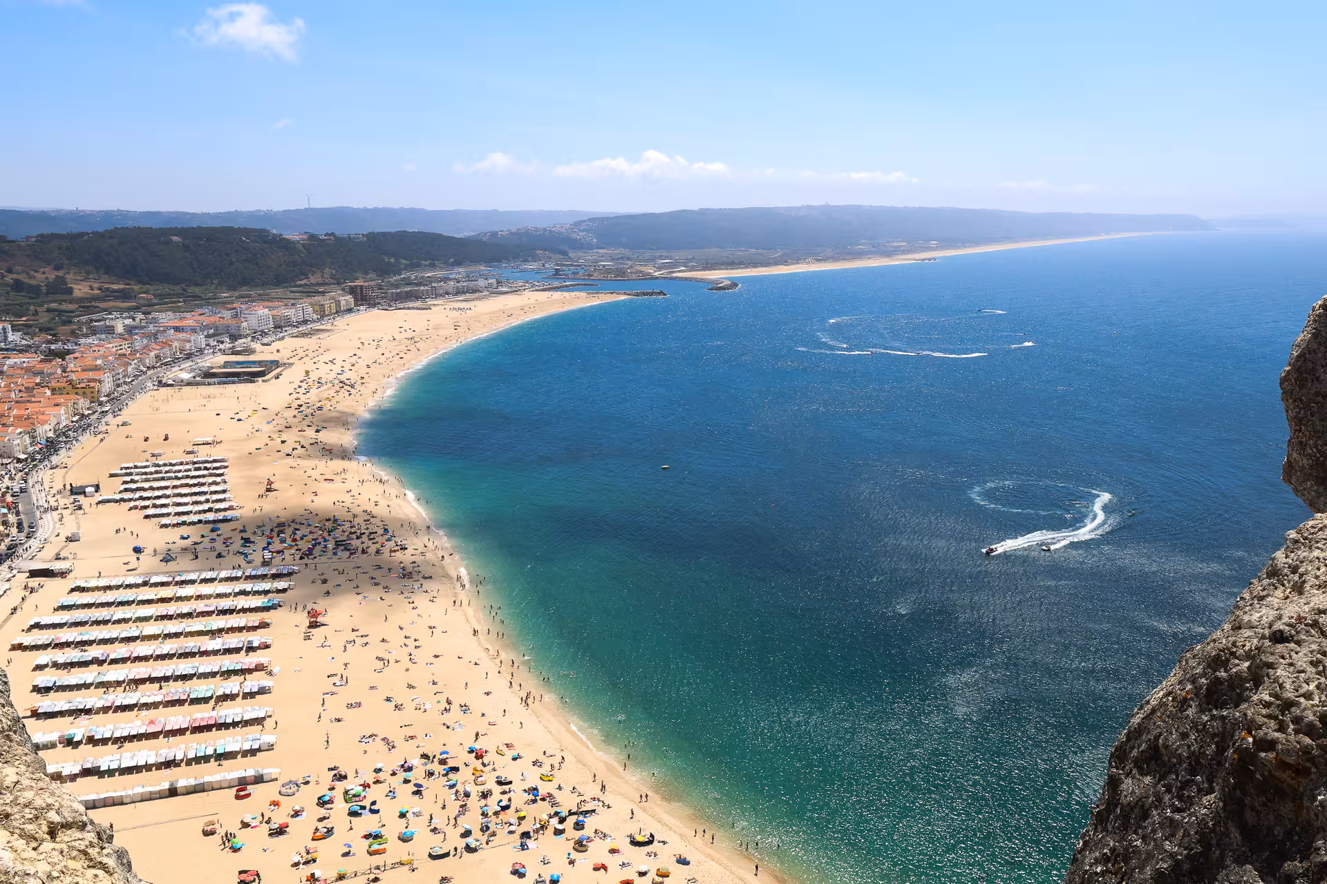 Aerial view of Nazaré's sandy beach and vibrant coastline, a highlight on the Lisbon to Óbidos tour.