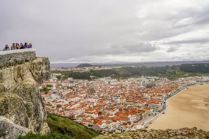 Tourists enjoy breathtaking views of Nazare's coastline and charming town during a private day tour from Lisbon to Fatima, Nazare, and Obidos.