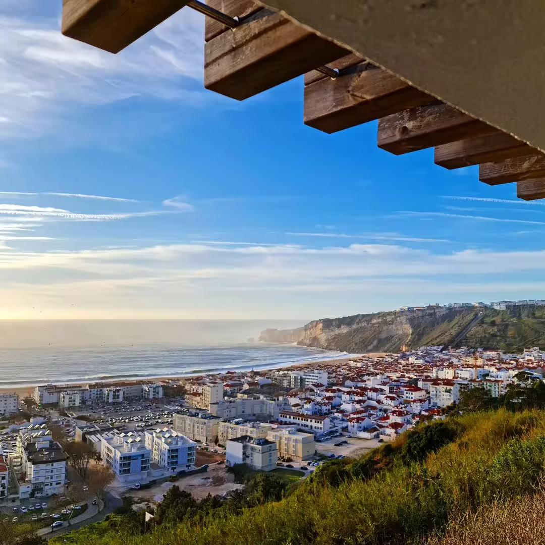 View of Nazaré coastline with dramatic cliffs and ocean, showcasing the perfect setting for the Giant Waves Surf Experience.