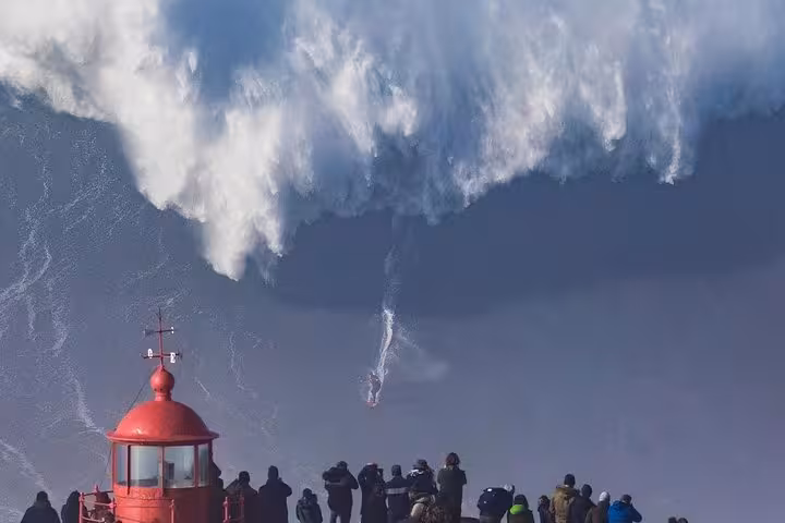 Big waves at Nazaré lighthouse viewpoint, a popular stop on Lisbon to Porto private tour along the coast