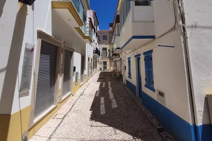 Charming narrow street in Nazaré with traditional Portuguese architecture, captured on a sunny day during a private tour from Lisbon.