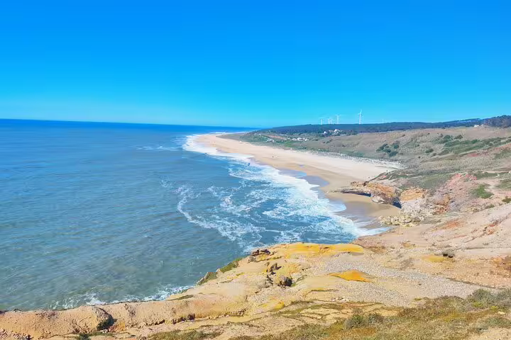 Scenic view of the expansive Praia do Norte beach and Atlantic Ocean in Nazaré, Portugal.