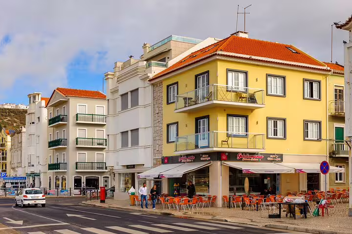 Nazaré seaside town square with colorful buildings and outdoor cafés on a Lisbon day trip tour