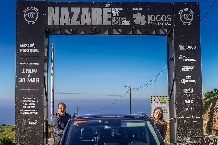 Tourists enjoy the iconic Nazare surfing site, part of the Fatima, Nazare, and Obidos full-day private tour from Lisbon.