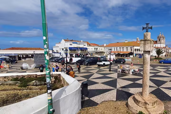 Scenic view of Nazaré town square with historic architecture and vibrant atmosphere on a sunny day during a Fátima, Nazaré, Batalha, and Óbidos tour.