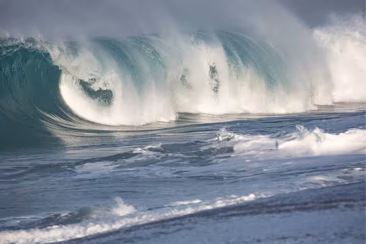 Massive waves crashing on Nazare beach, famous for surfing and coastal beauty on a private car tour.