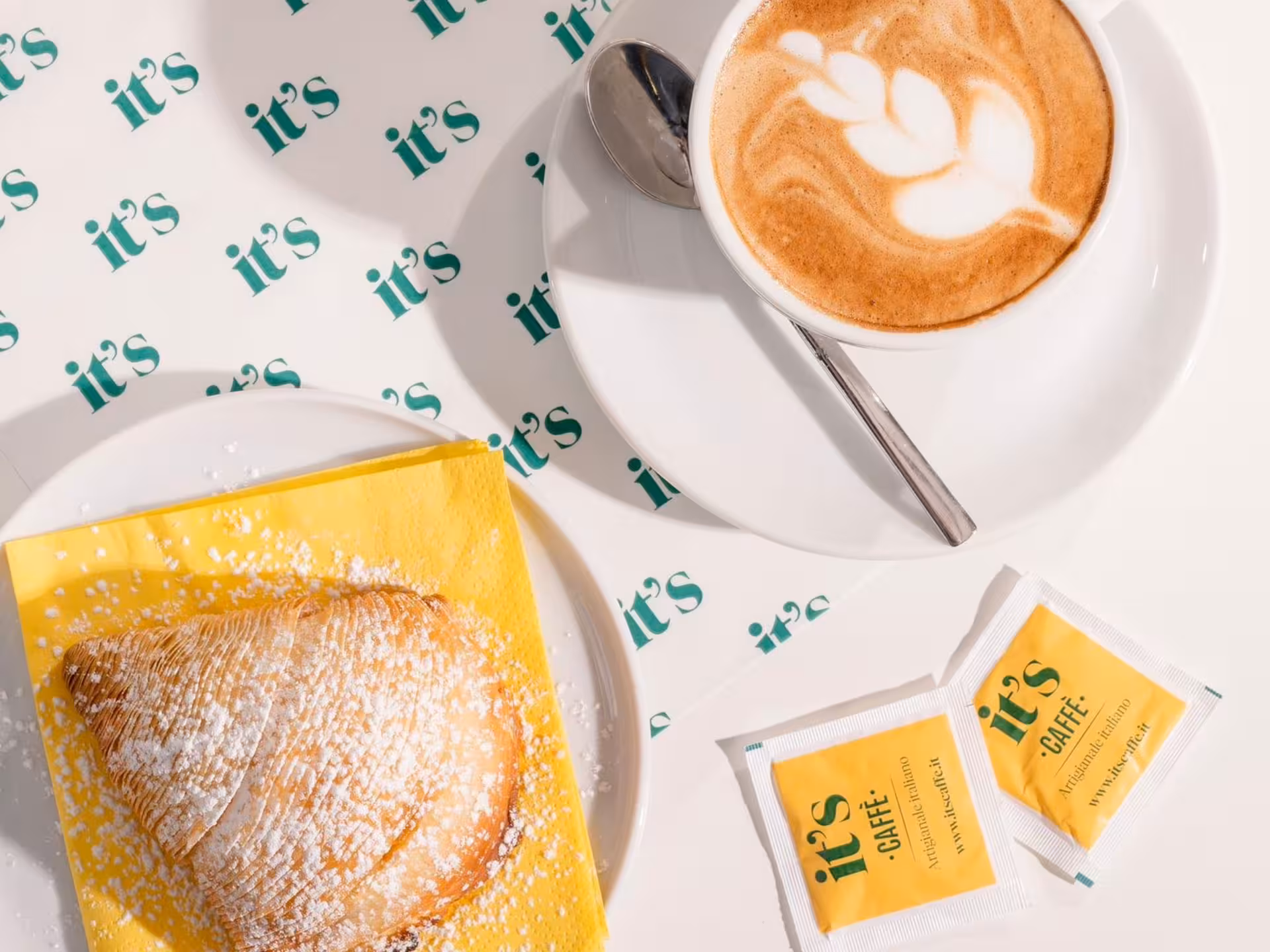 Indulge in a Neapolitan coffee with latte art and a sugar-dusted pastry for a delightful tasting experience.