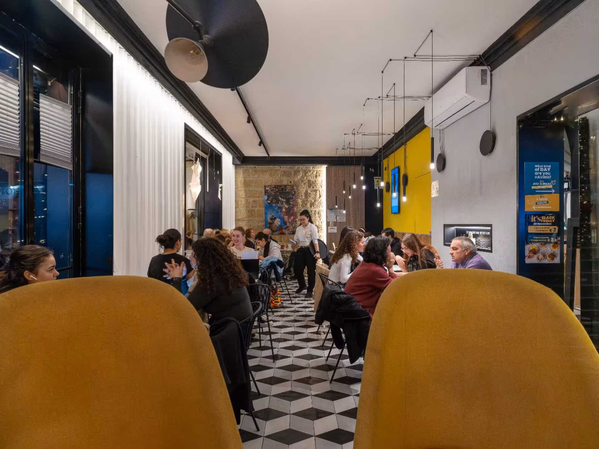 A cozy café ambiance filled with guests enjoying the Neapolitan coffee tasting experience in a modern setting.