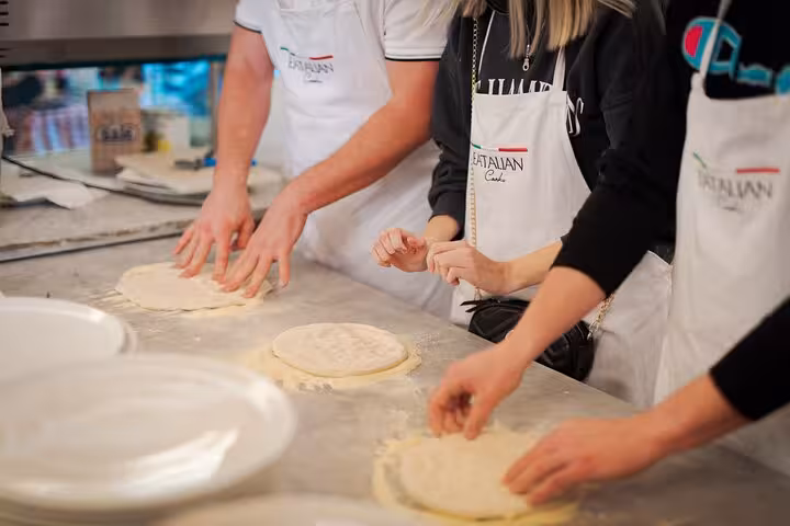 Close-up of students learning to prepare pizza dough in a Rome city center cooking class near Piazza Navona.