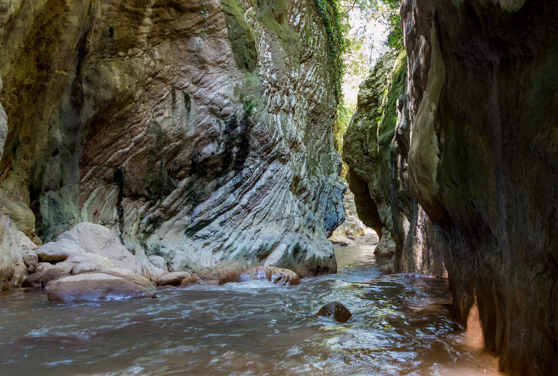 Neda River Trekking canyon with clear stream, smooth limestone walls and shaded gorge on Corfu adventure
