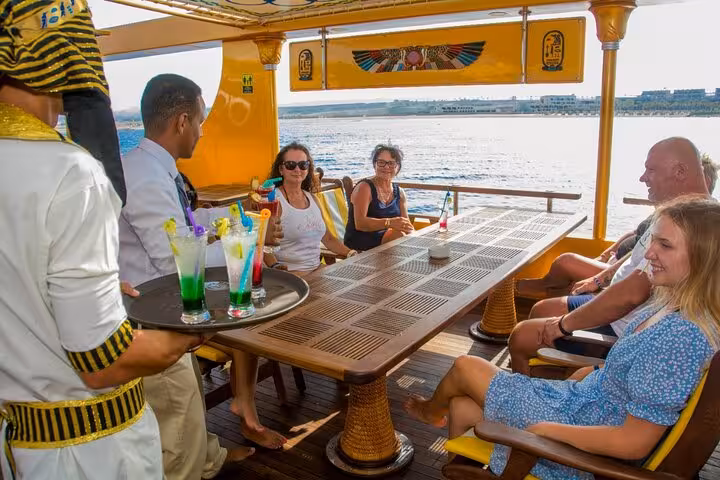 Guests relax on Nefertari snorkeling cruise deck from Makadi with pickup, enjoying drinks on the Red Sea