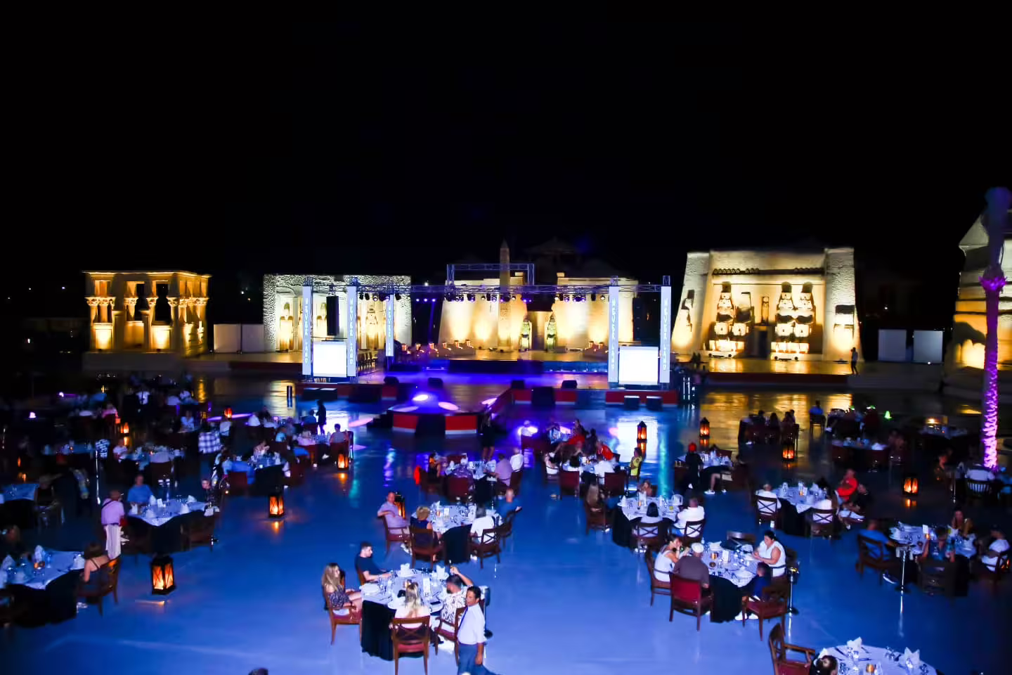 Open-air dinner seating facing the illuminated stage at Neverland Musical and Cabaret Show in Sharm El Sheikh