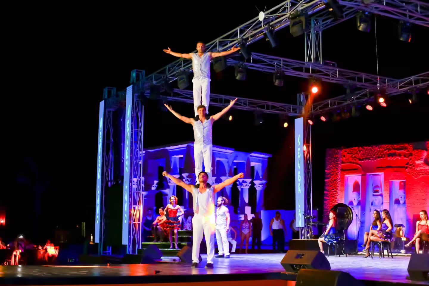 Neverland Show Sharm El Sheikh acrobatic pyramid act on open-air stage with colorful lights and live performers