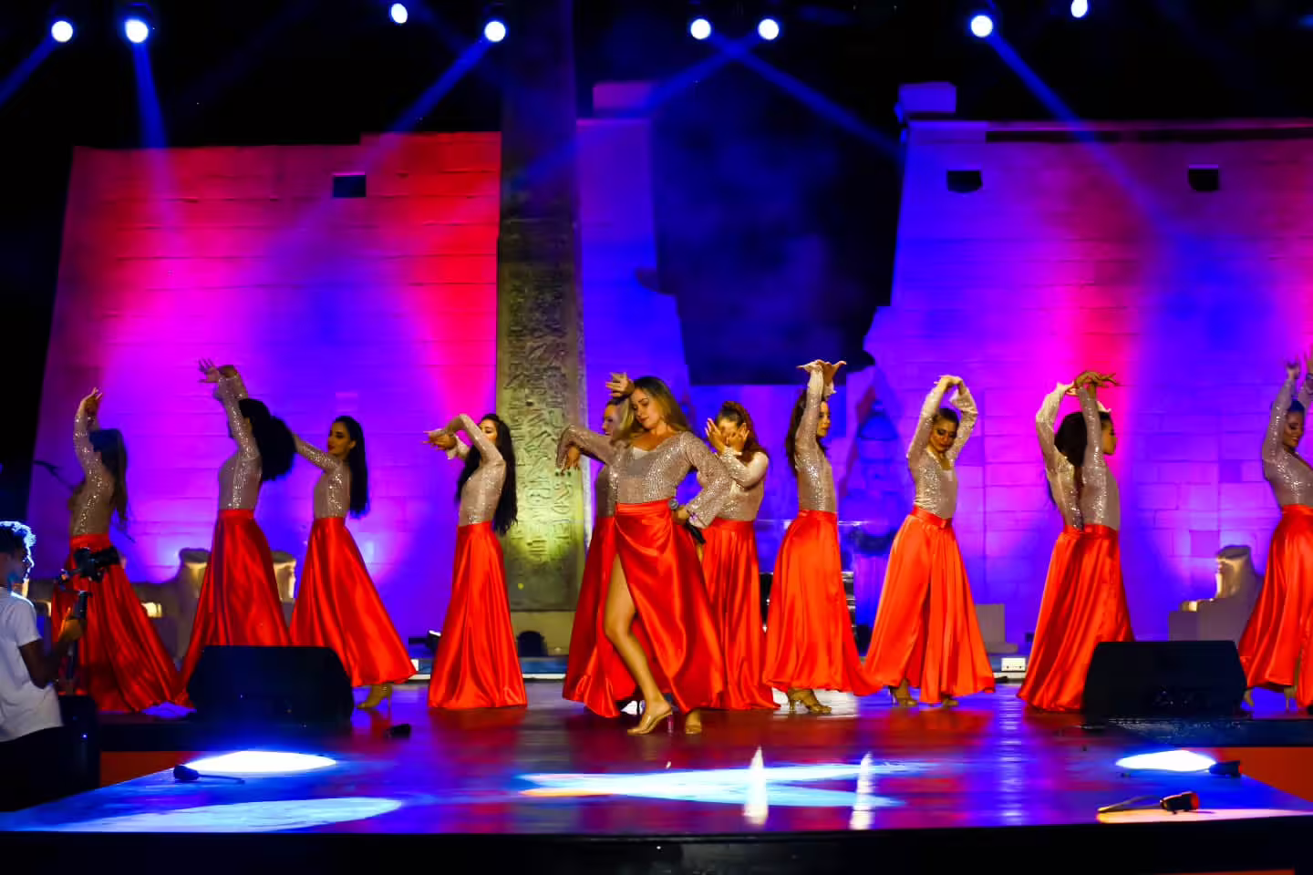 Neverland Show Sharm El Sheikh dancers in red skirts performing on a lit stage with Egyptian-style backdrop