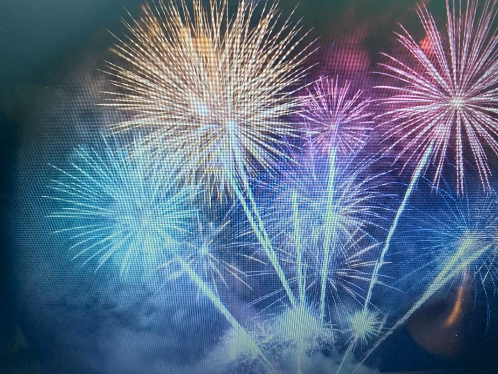 Bright New Year’s Eve fireworks bursts over the water, seen from a sailboat cruise for midnight celebrations
