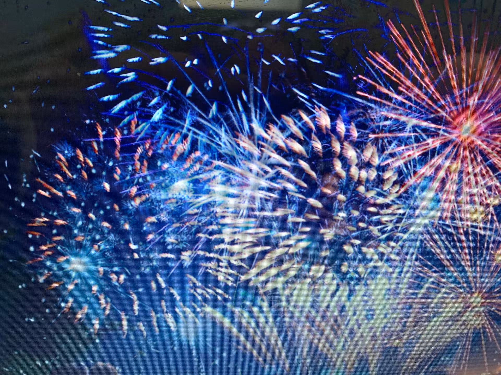 Colorful New Year’s Eve fireworks bursting over the bay, viewed from a sailboat cruiser night tour
