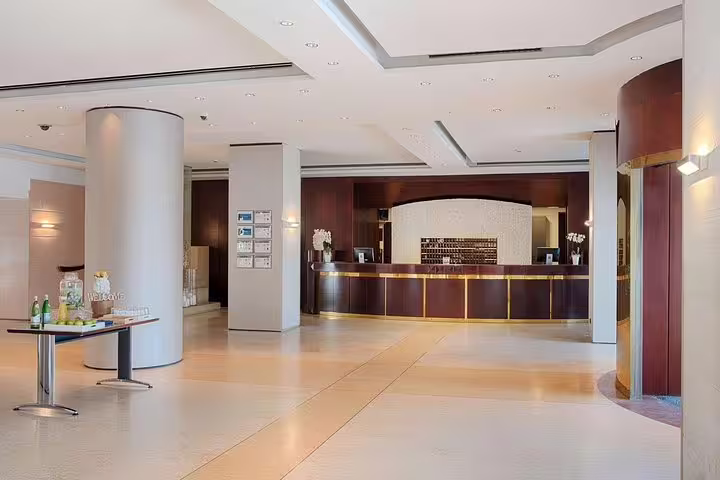 Spacious, modern reception lobby of NH Palermo Hotel in Sicily for guests arriving by private Palermo airport transfer