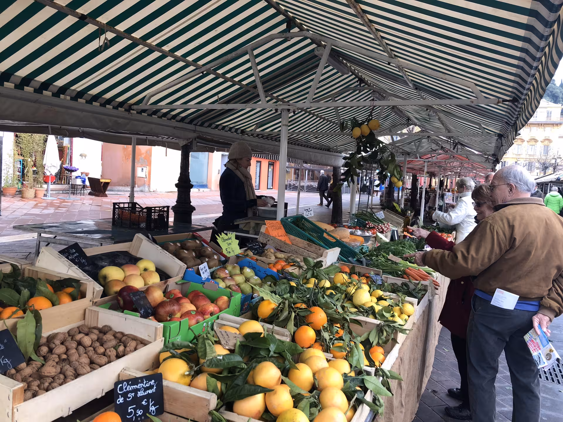 Fresh fruits and vegetables at a bustling Nice market, perfect for exploring local flavors on an evening food tour.