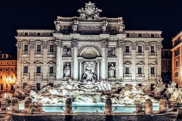 Night view of the illuminated Trevi Fountain in Rome, a highlight of the golf cart tour with free pick-up.