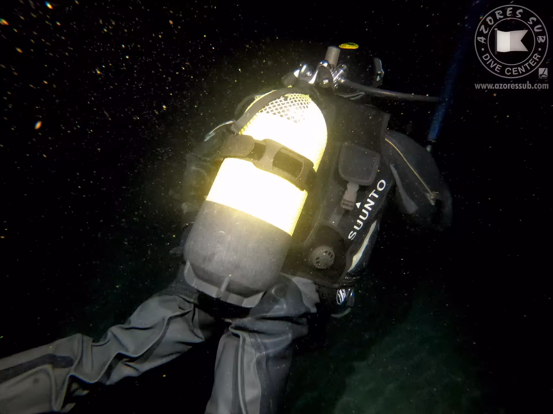 Night scuba diver with tank and BCD swimming in dark water, ideal for Azores guided night dive adventure