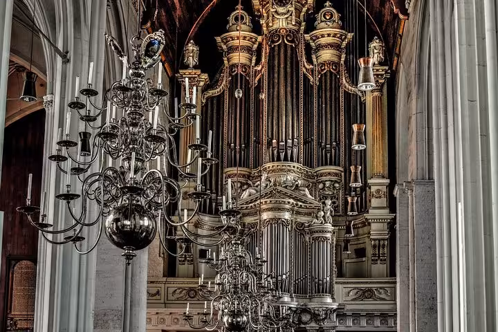 Ornate pipe organ and chandeliers inside Nijmegen church, ideal cultural highlight on private transfer from Amsterdam