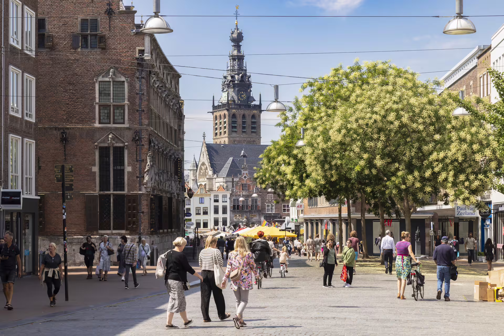 Nijmegen city center street with shoppers and St Stevenskerk tower, featured on 1-day audioguide walking tour