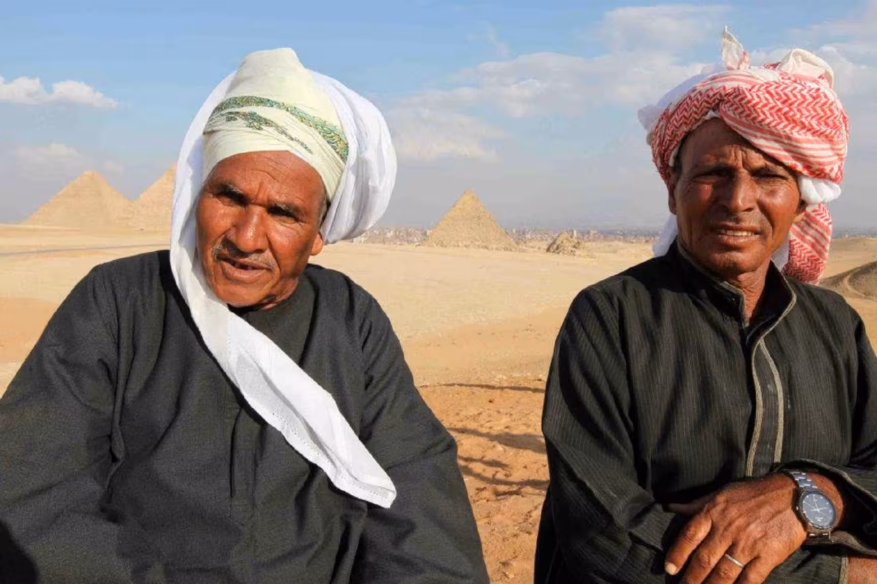 Local Egyptian guides in traditional headscarves with Giza pyramids backdrop, Nile Adventure felucca cruise tour