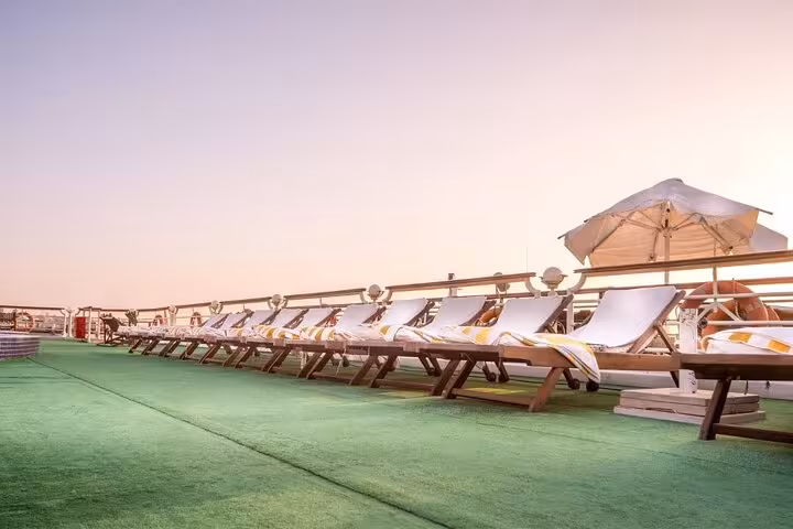 Sun loungers and umbrella on Nile cruise sundeck, Aswan to Luxor 4-day cruise tour relaxation