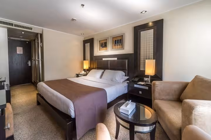 Spacious Nile cruise cabin with queen bed and seating, perfect for 4-day Aswan Luxor cruise with Abu Simbel