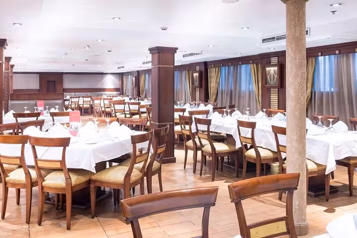 Nile cruise dining room with set tables, onboard meals during 5-day Luxor to Aswan cruise with Abu Simbel