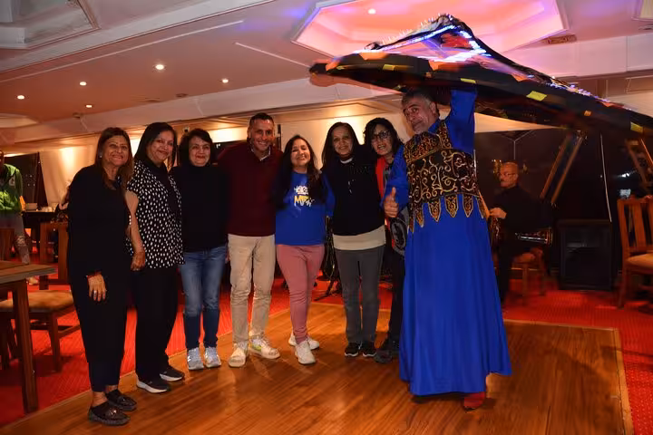 Group enjoys a lively Tanura dance performance on a Nile cruise dinner, showcasing vibrant cultural experiences.