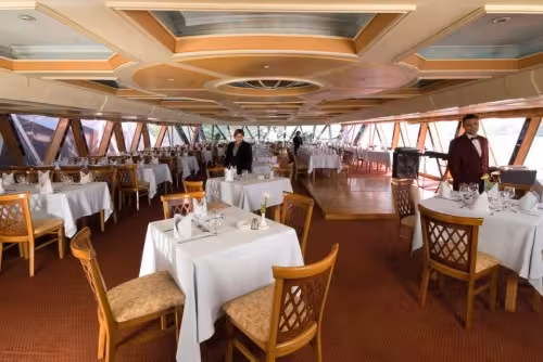 Elegant indoor restaurant on Nile Crystal floating dinner cruise in Cairo, set tables for buffet and show