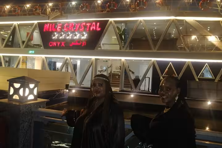 Nile Crystal dinner cruise boat in Cairo at night, guests boarding for buffet dinner with belly dancing show