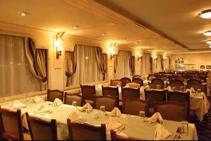 Elegant Nile dinner cruise dining room in Cairo with set tables for belly dancing and folklore show