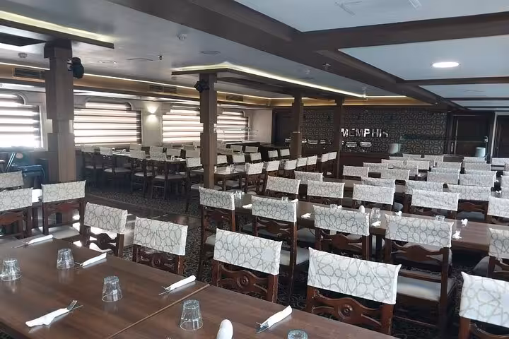 Spacious dining hall on Cairo Nile dinner cruise boat with set tables for buffet and folklore show night