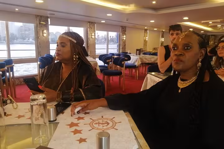 Guests seated in Nile dinner cruise dining hall in Cairo, enjoying onboard folklore show atmosphere