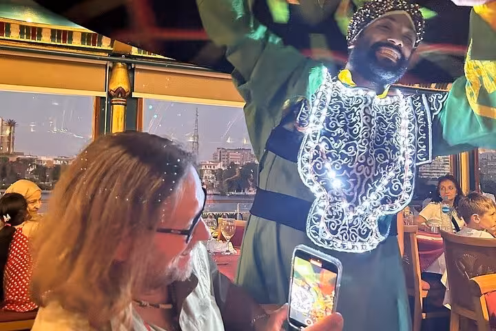 Tanoura dancer entertains guests on Cairo Nile River dinner cruise with live traditional music onboard