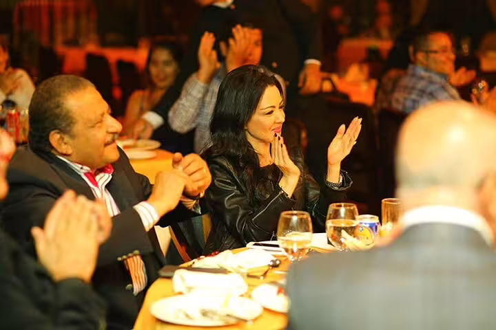 Guests applauding during live belly dancer and tannura performance on Nile Maxim dinner cruise in Cairo at night