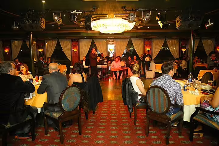Nile Maxim dinner cruise in Cairo dining hall with live music stage, Oriental show seating and evening ambiance